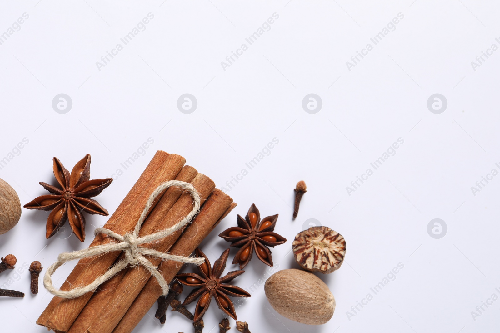 Photo of Different spices and nuts on white background, flat lay. Space for text