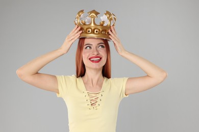 Photo of Beautiful young woman with inflatable crown on light grey background