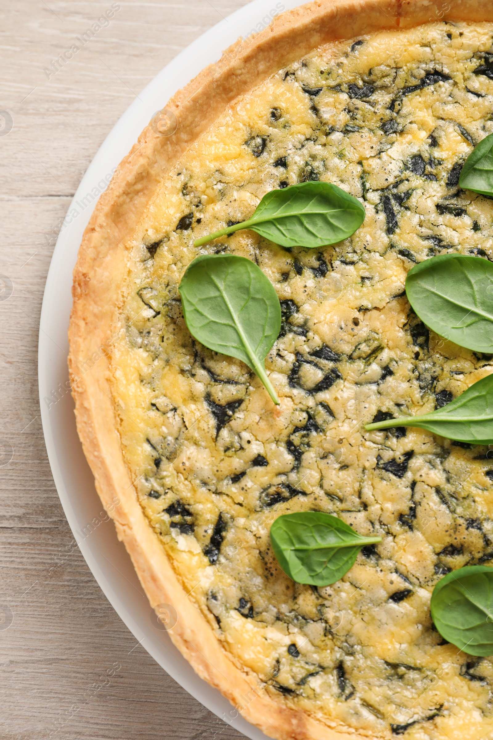 Photo of Delicious homemade spinach pie on white wooden table, top view