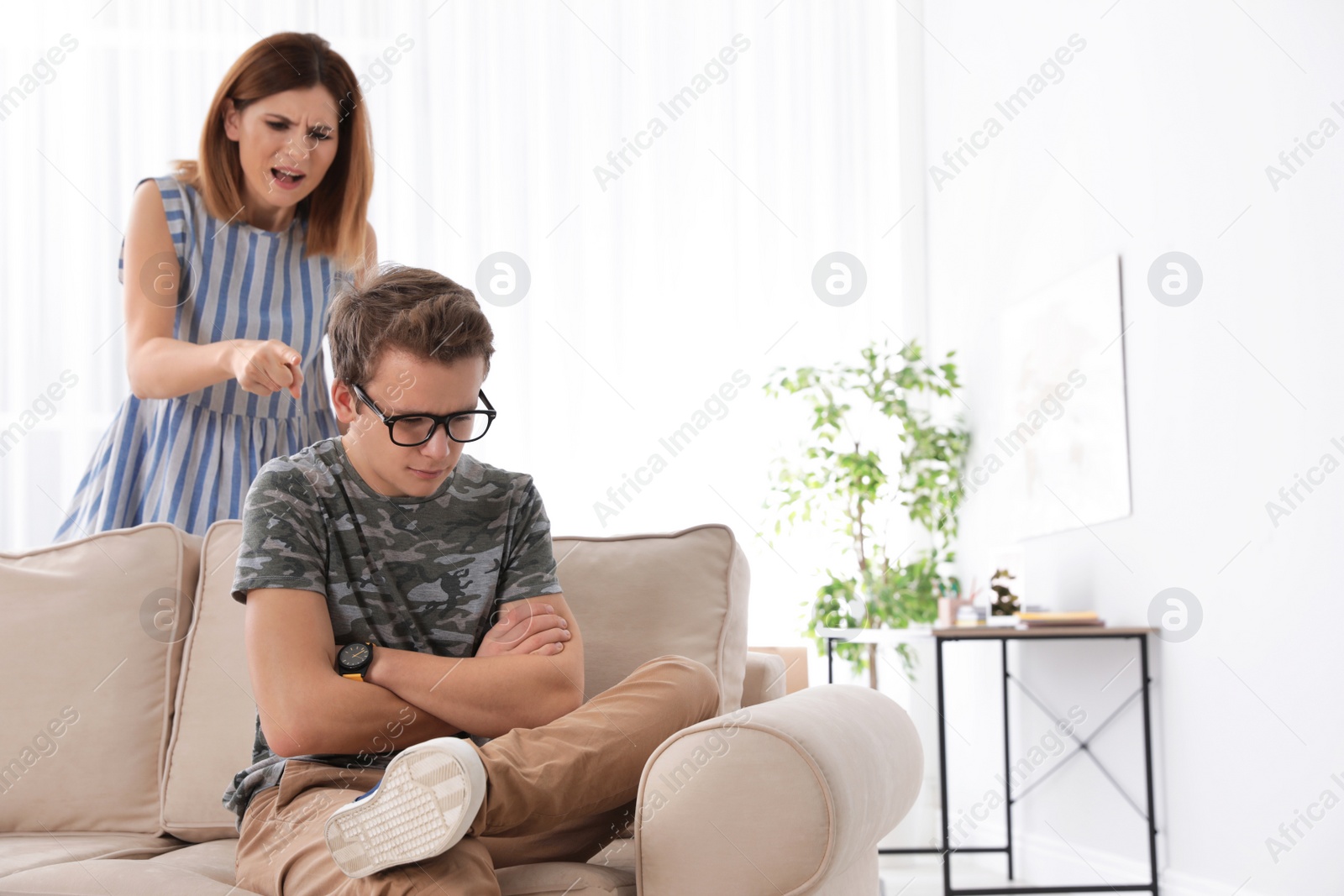 Photo of Mother scolding her teenager son at home