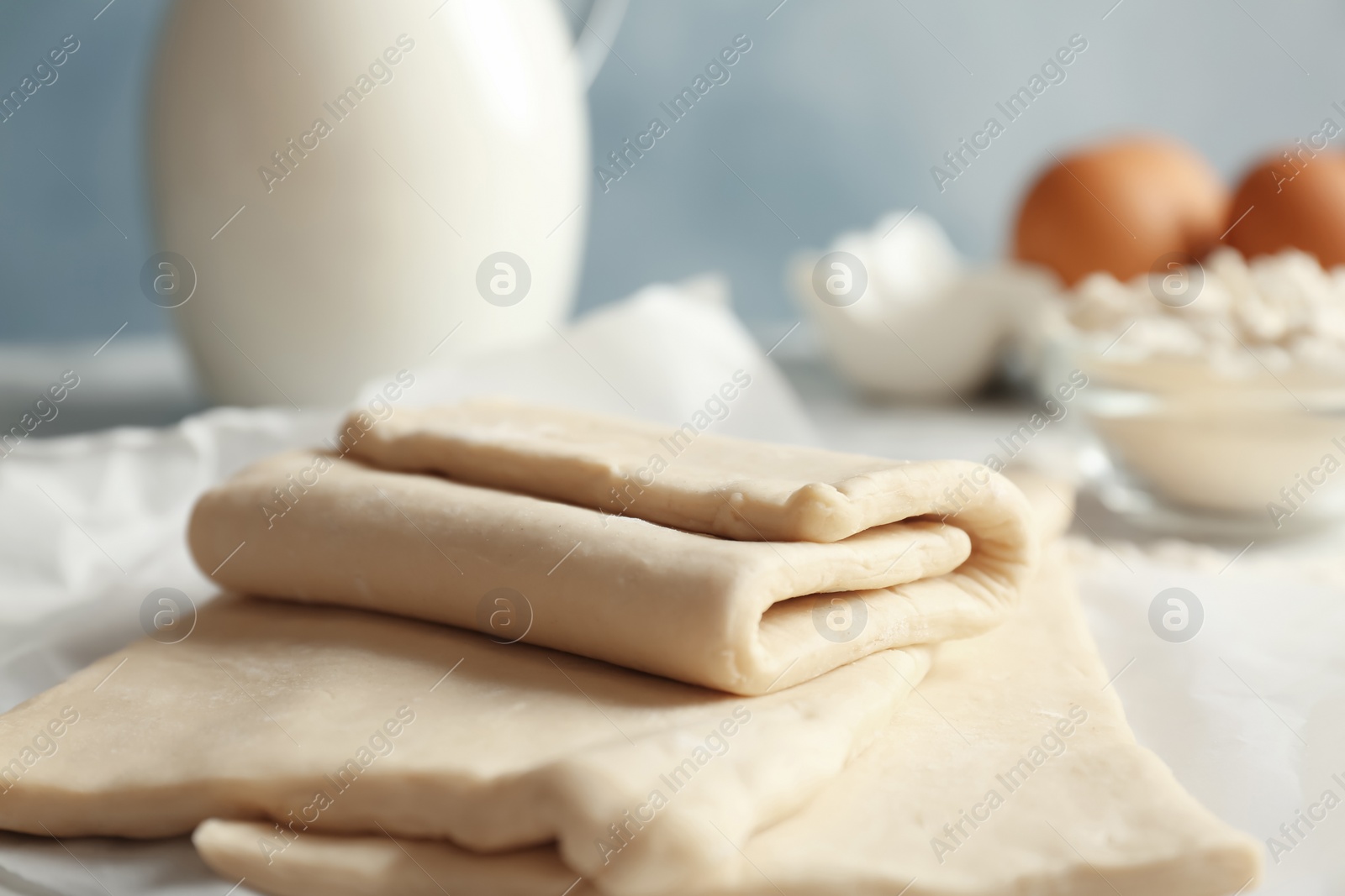 Photo of Fresh raw dough on parchment paper, closeup