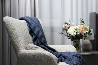 Photo of Bouquet of beautiful flowers near armchair indoors