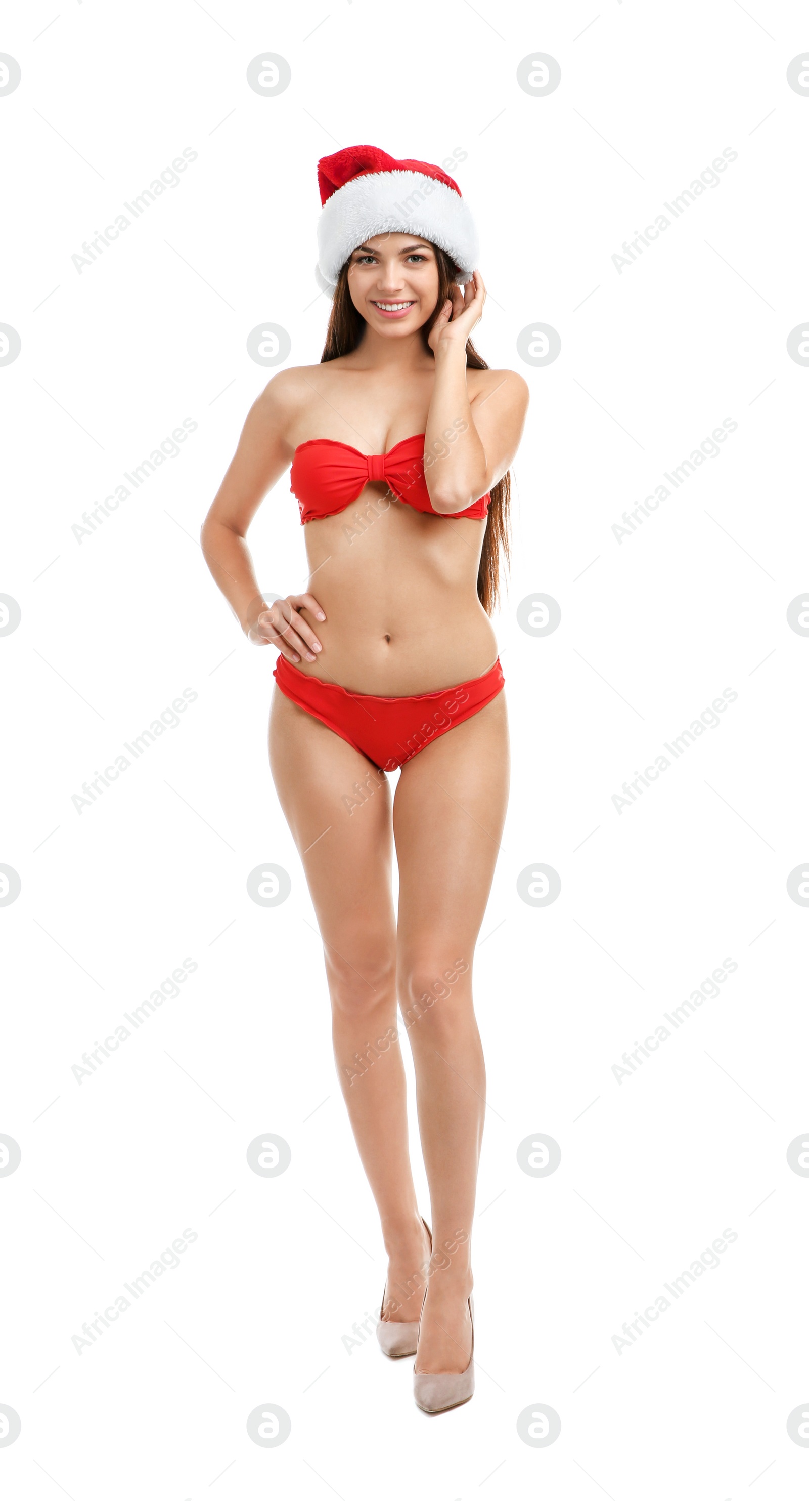 Photo of Young beautiful woman in swimsuit and Santa hat on white background. Christmas celebration