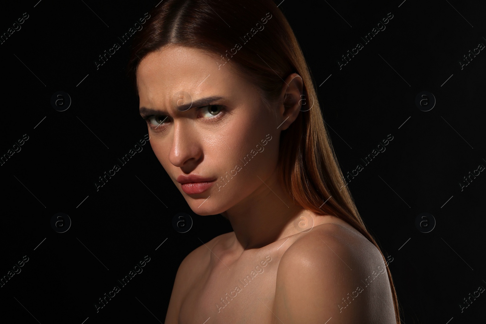 Photo of Evil eye. Young woman with scary eyes on black background