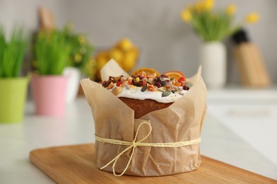 Photo of Traditional Easter cake with dried fruits on table in kitchen