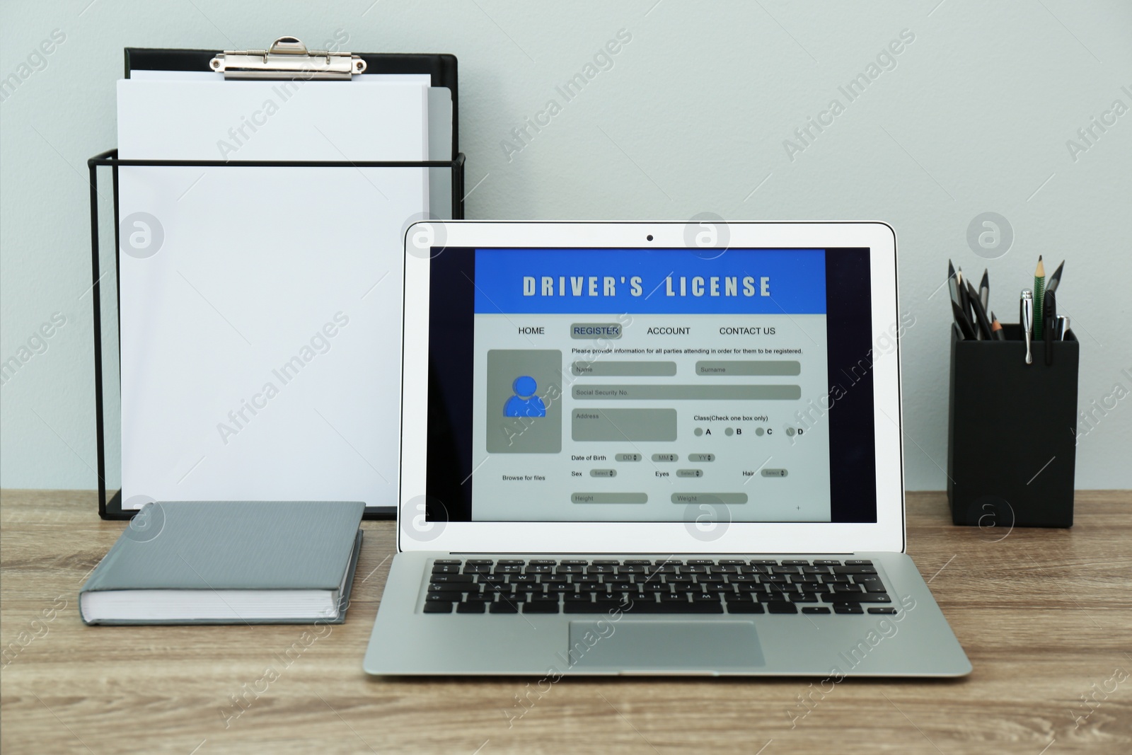 Photo of Laptop with driver's license application form on table in office