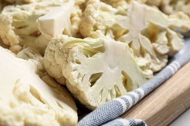 Cut fresh raw cauliflower on wooden tray, closeup