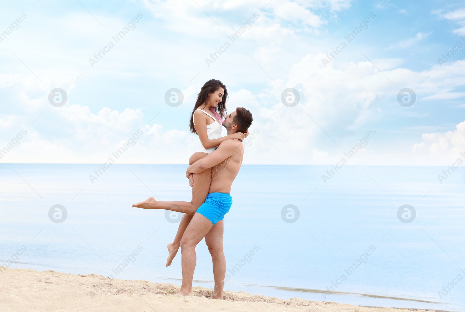 Photo of Happy young couple spending time together on beach near sea