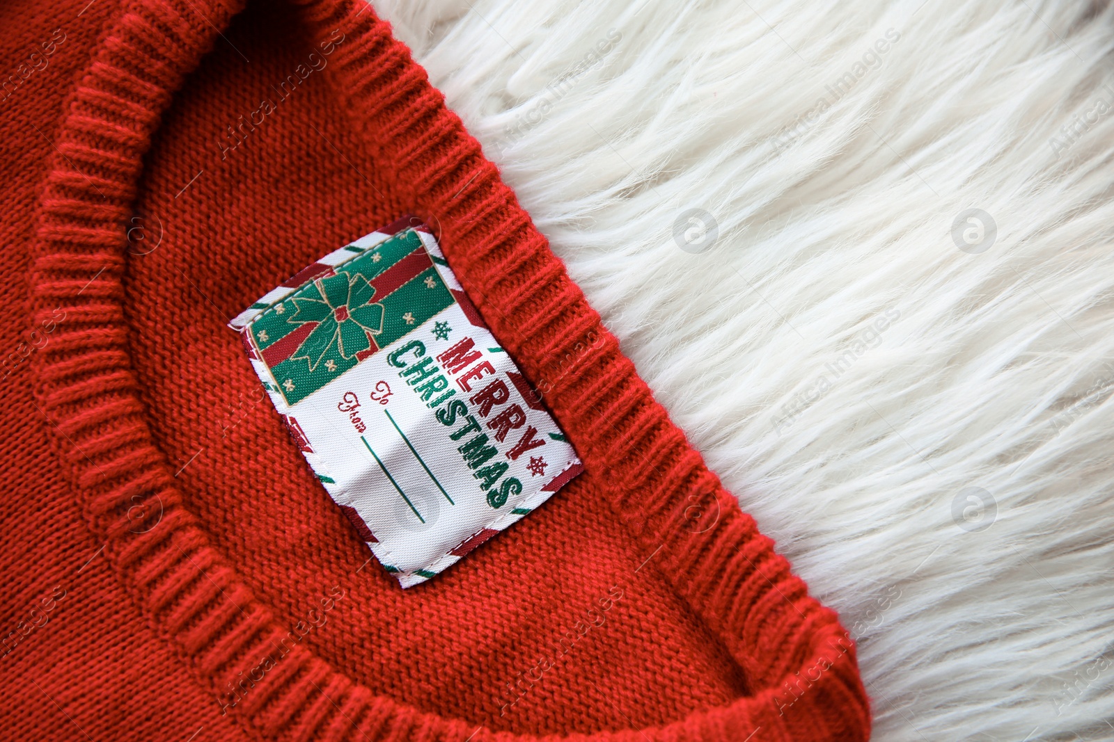 Photo of Christmas sweater with tag on fur, closeup