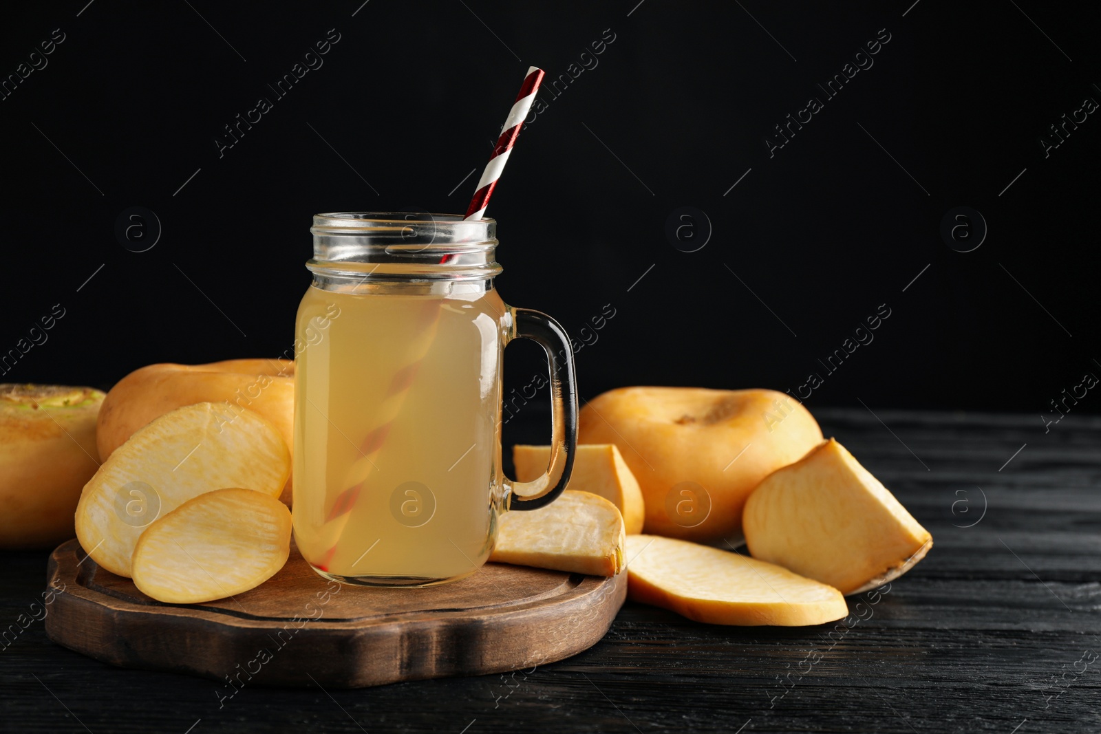 Photo of Freshly made turnip juice on black wooden table, space for text