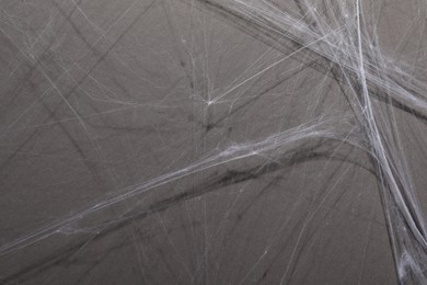 Photo of Creepy white cobweb hanging on gray background