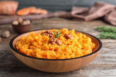 Photo of Bowl with mashed sweet potatoes on wooden table