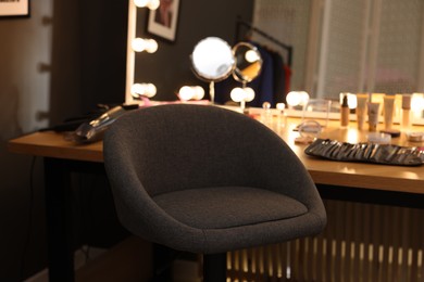Photo of Makeup room. Chair near dressing table with different beauty products