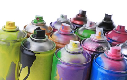 Photo of Used cans of spray paints on white background, closeup. Graffiti supplies