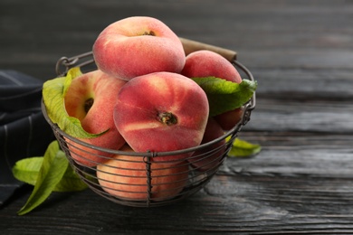 Photo of Fresh ripe donut peaches on black wooden table