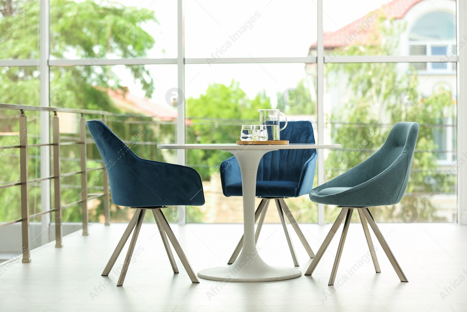 Photo of Stylish room interior with round table and comfortable chairs