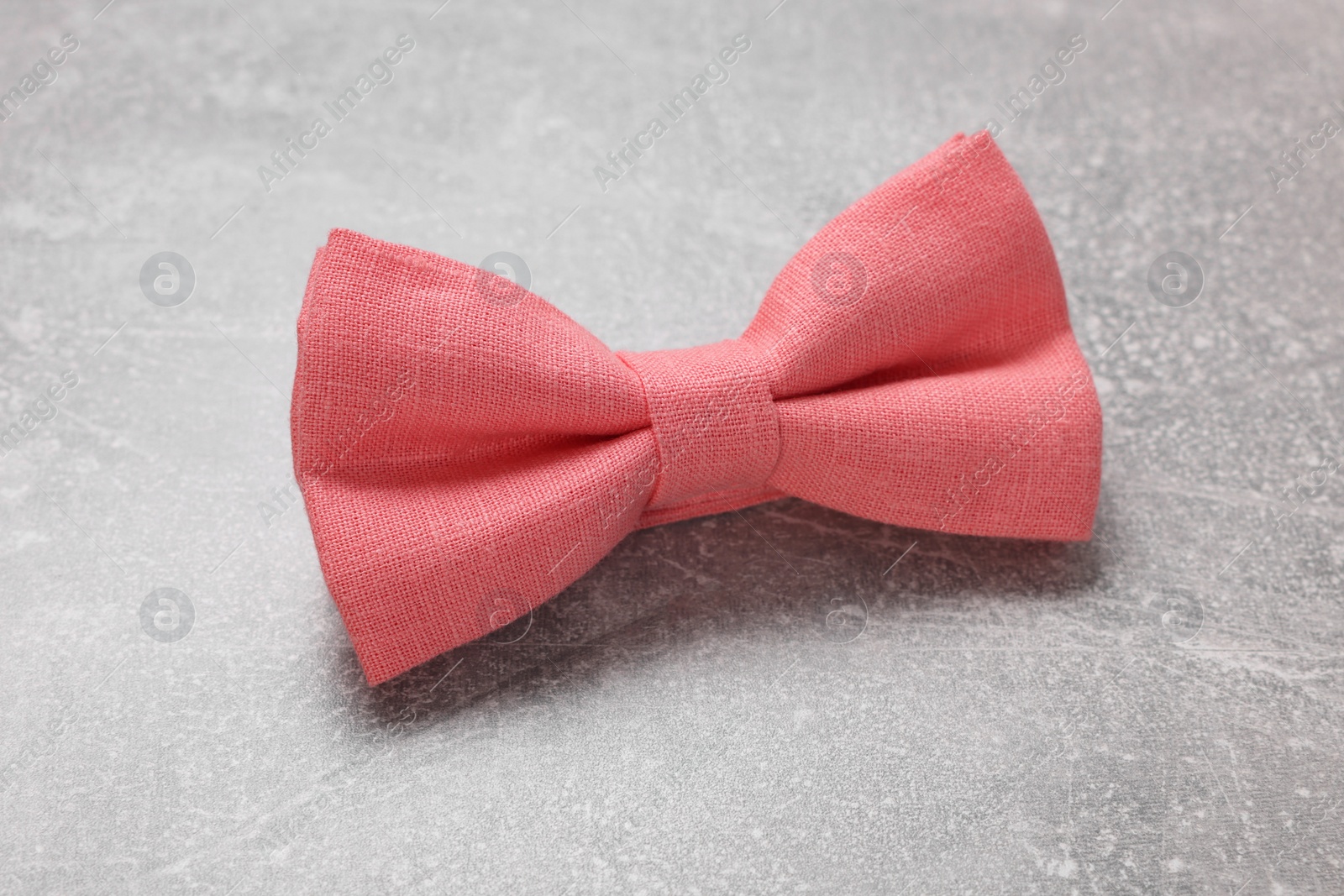 Photo of Stylish coral bow tie on light grey background