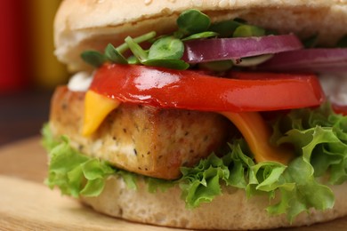 Photo of Delicious burger with tofu and fresh vegetables on board, closeup