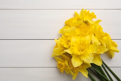 Beautiful daffodil bouquet on white wooden table, top view. Space for text