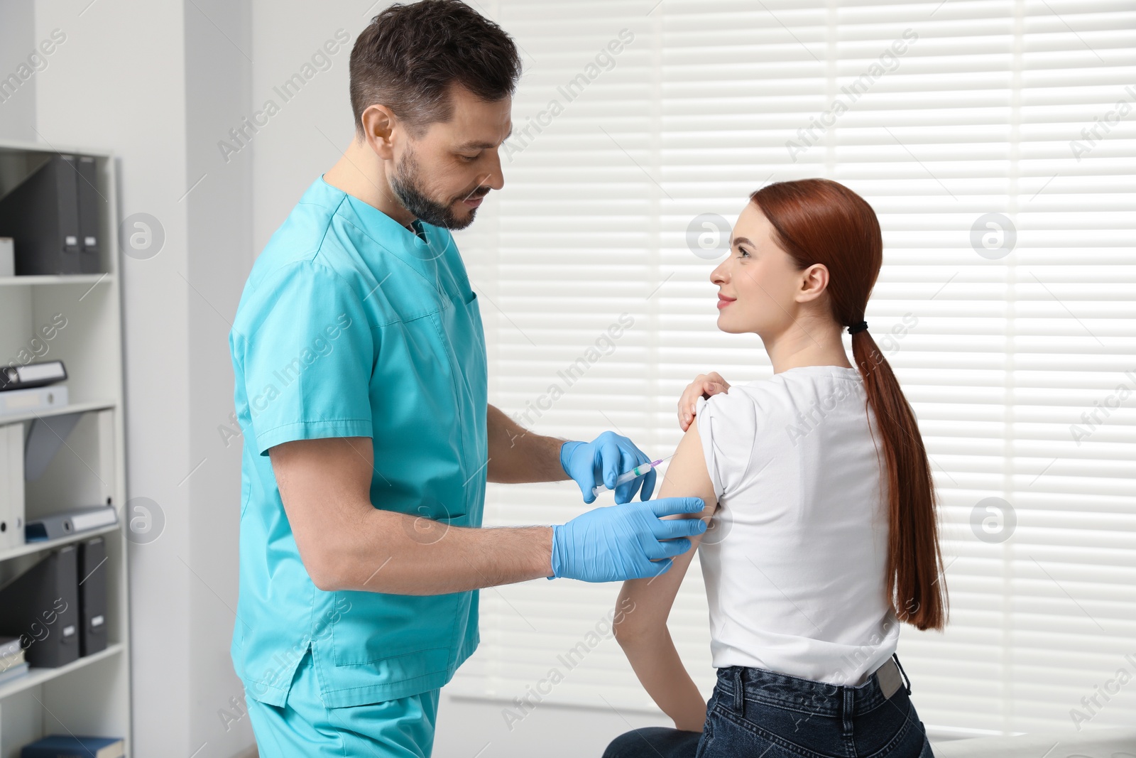 Photo of Doctor giving hepatitis vaccine to patient in clinic