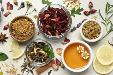 Flat lay composition with fresh brewed tea and dry leaves on light table