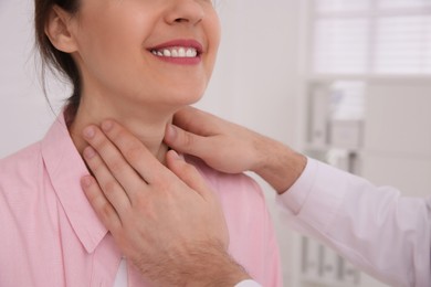 Doctor examining thyroid gland of patient indoors, closeup