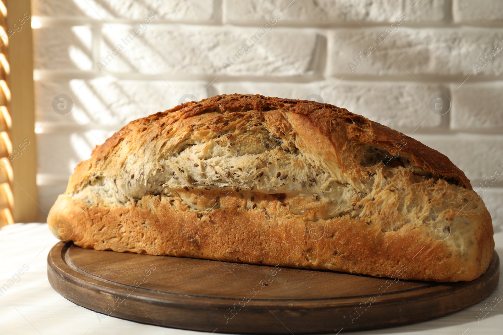 Photo of Freshly baked sourdough bread on white wooden table indoors