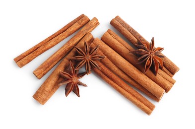 Photo of Aromatic cinnamon sticks and anise stars isolated on white, top view