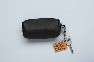 Photo of Leather case with key on light grey background, top view
