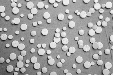 Photo of White pills on grey background, flat lay