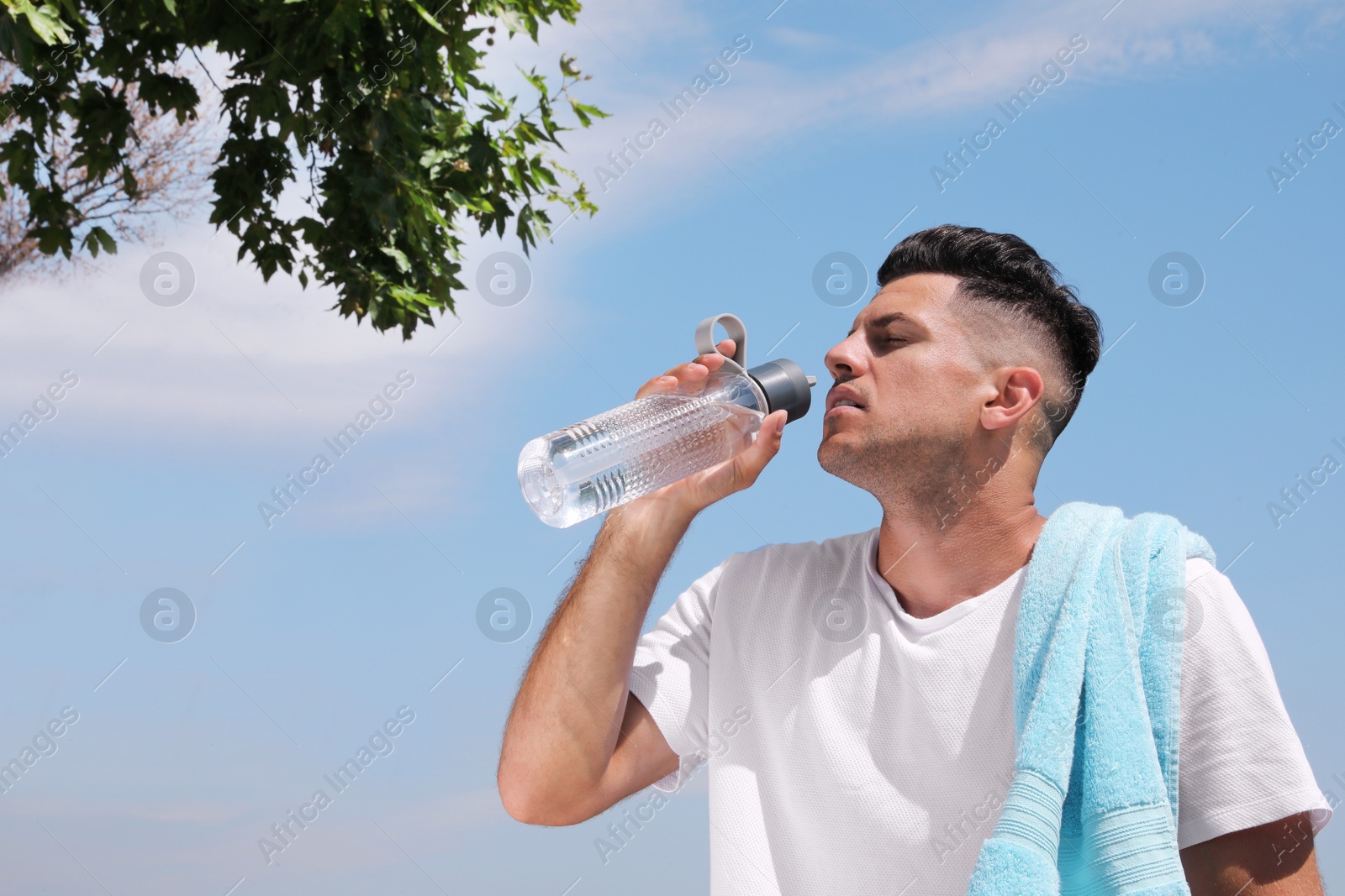 Photo of Man drinking water to prevent heat stroke outdoors