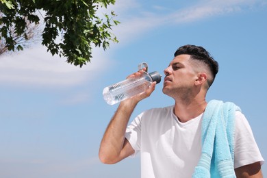 Photo of Man drinking water to prevent heat stroke outdoors