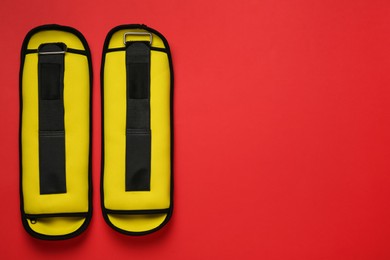 Photo of Yellow weighting agents on red background, flat lay. Space for text