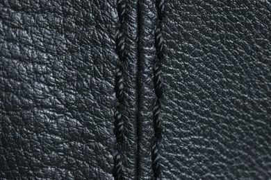 Black leather with seam as background, top view