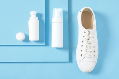 Flat lay composition with stylish footwear and shoe care accessories on light blue background