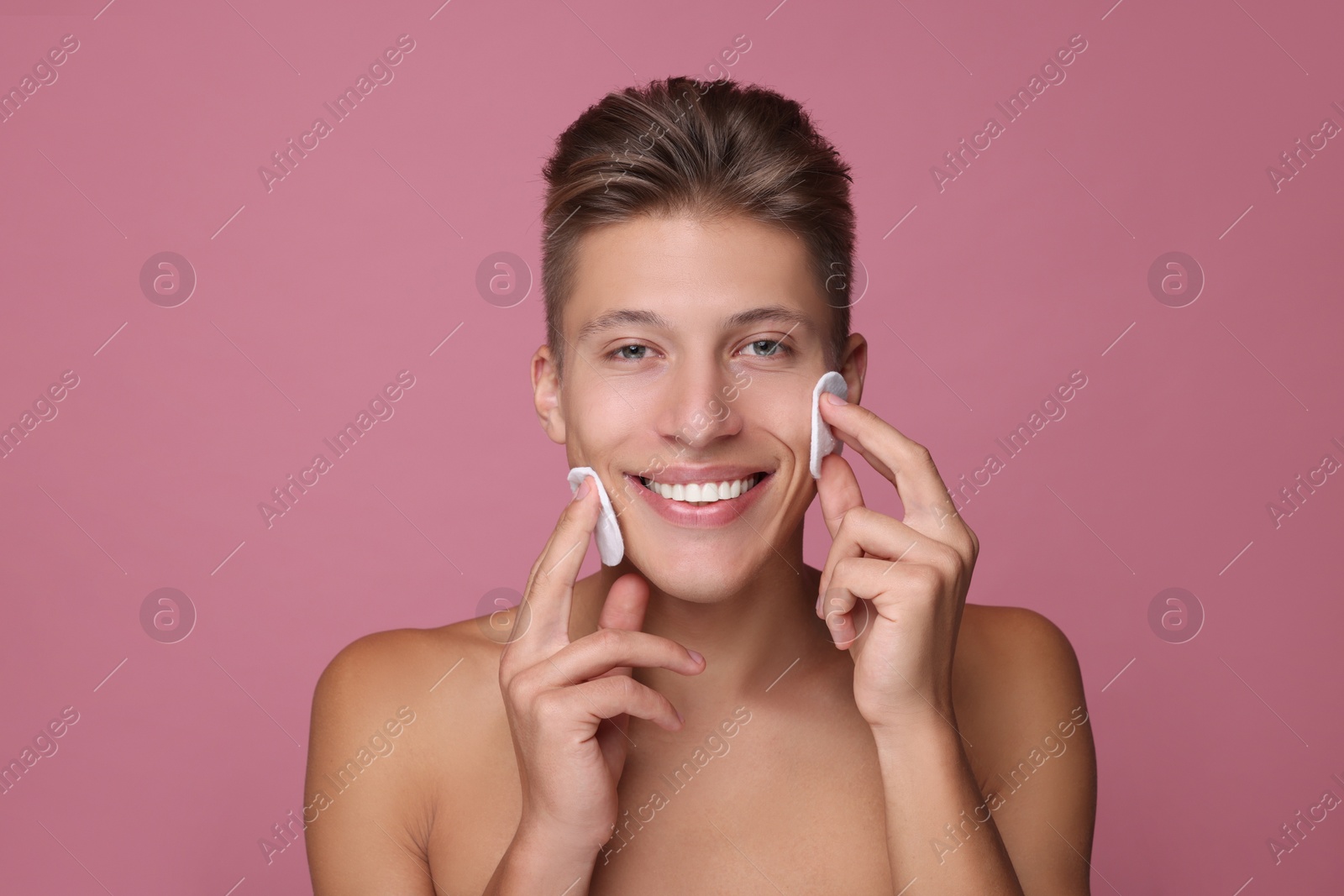 Photo of Handsome man with cotton pads on pink background