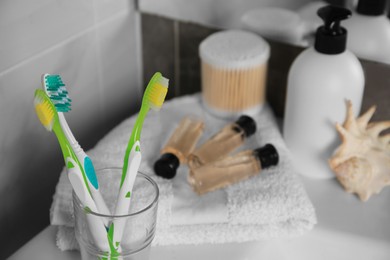 Photo of Colorful toothbrushes in glass holder on table indoors