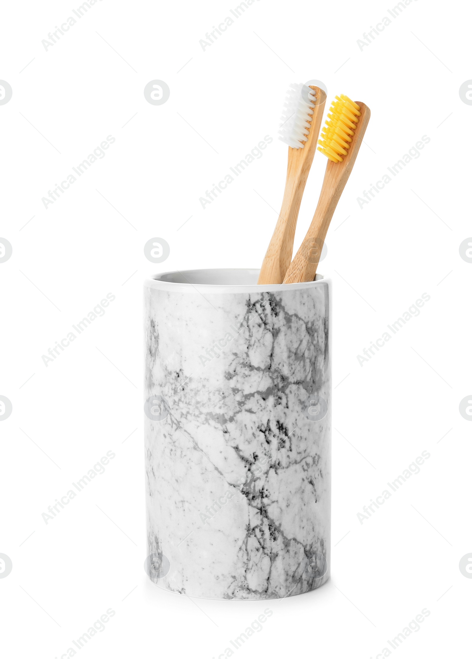 Photo of Bamboo toothbrushes in holder on white background. Dental care