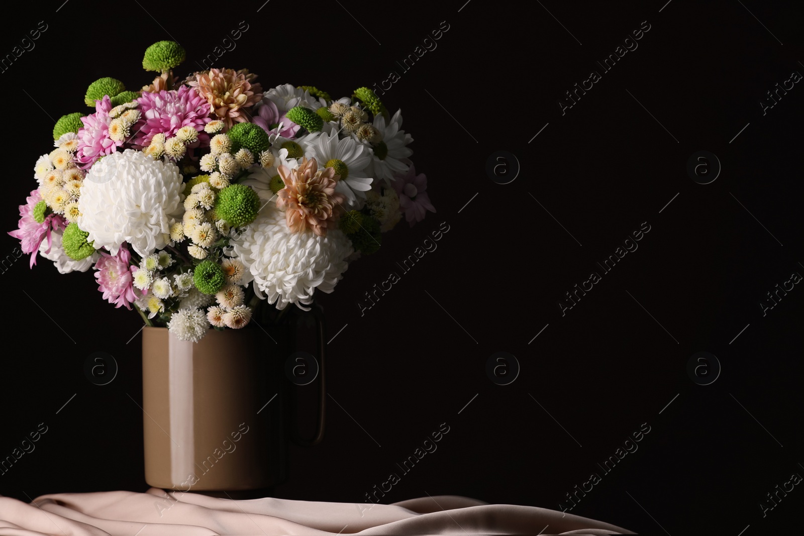 Photo of Bouquet of beautiful chrysanthemum flowers on table against dark background, space for text