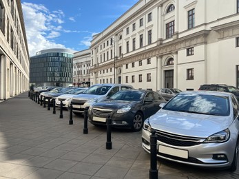 Photo of Different modern cars parked on city street
