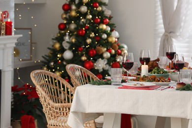 Photo of Festive dinner with delicious food and wine on table indoors. Christmas Eve celebration