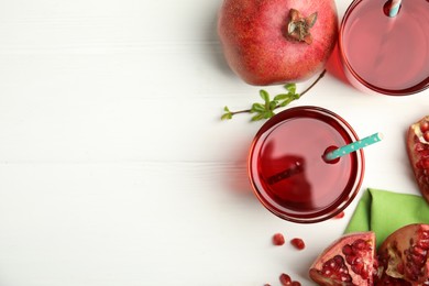 Photo of Pomegranate juice and fresh fruits on white wooden table, flat lay. Space for text
