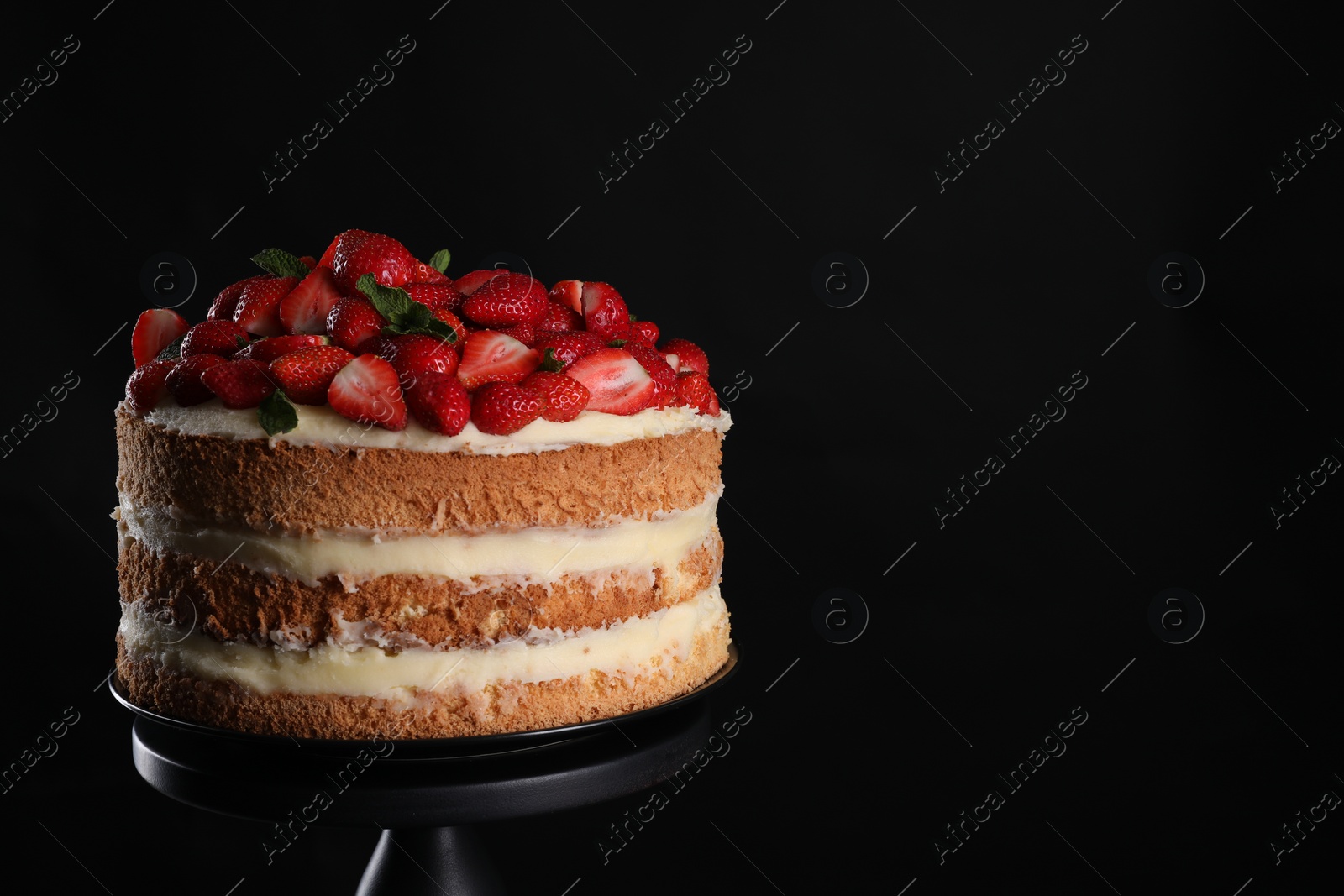 Photo of Tasty cake with fresh strawberries and mint on black background, space for text