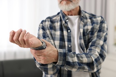 Photo of Arthritis symptoms. Man suffering from pain in wrist at home, closeup