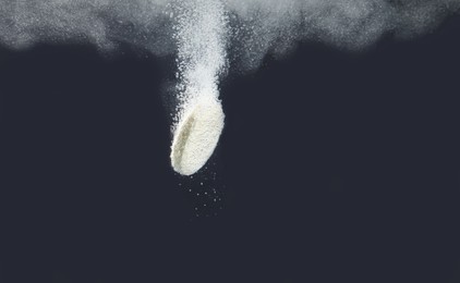 Effervescent pill dissolving in water on dark background, closeup