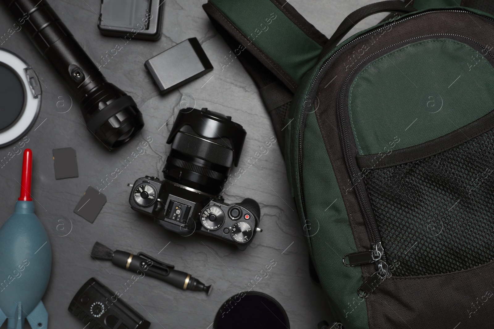 Photo of Professional photography equipment and backpack on slate table, flat lay
