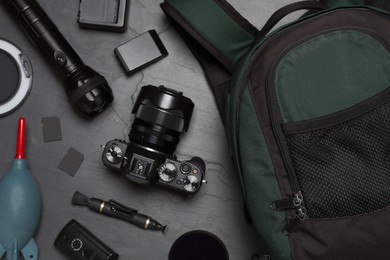 Professional photography equipment and backpack on slate table, flat lay