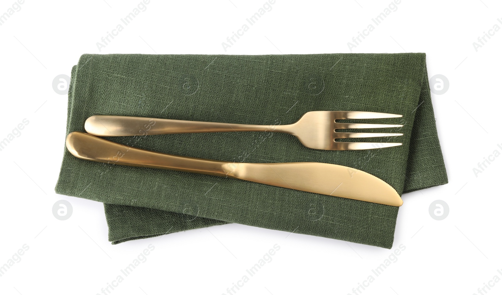 Photo of Green napkin with golden fork and knife isolated on white, top view. Cutlery set