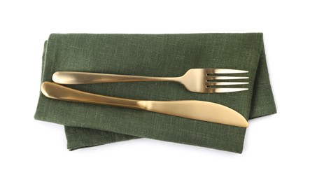 Photo of Green napkin with golden fork and knife isolated on white, top view. Cutlery set