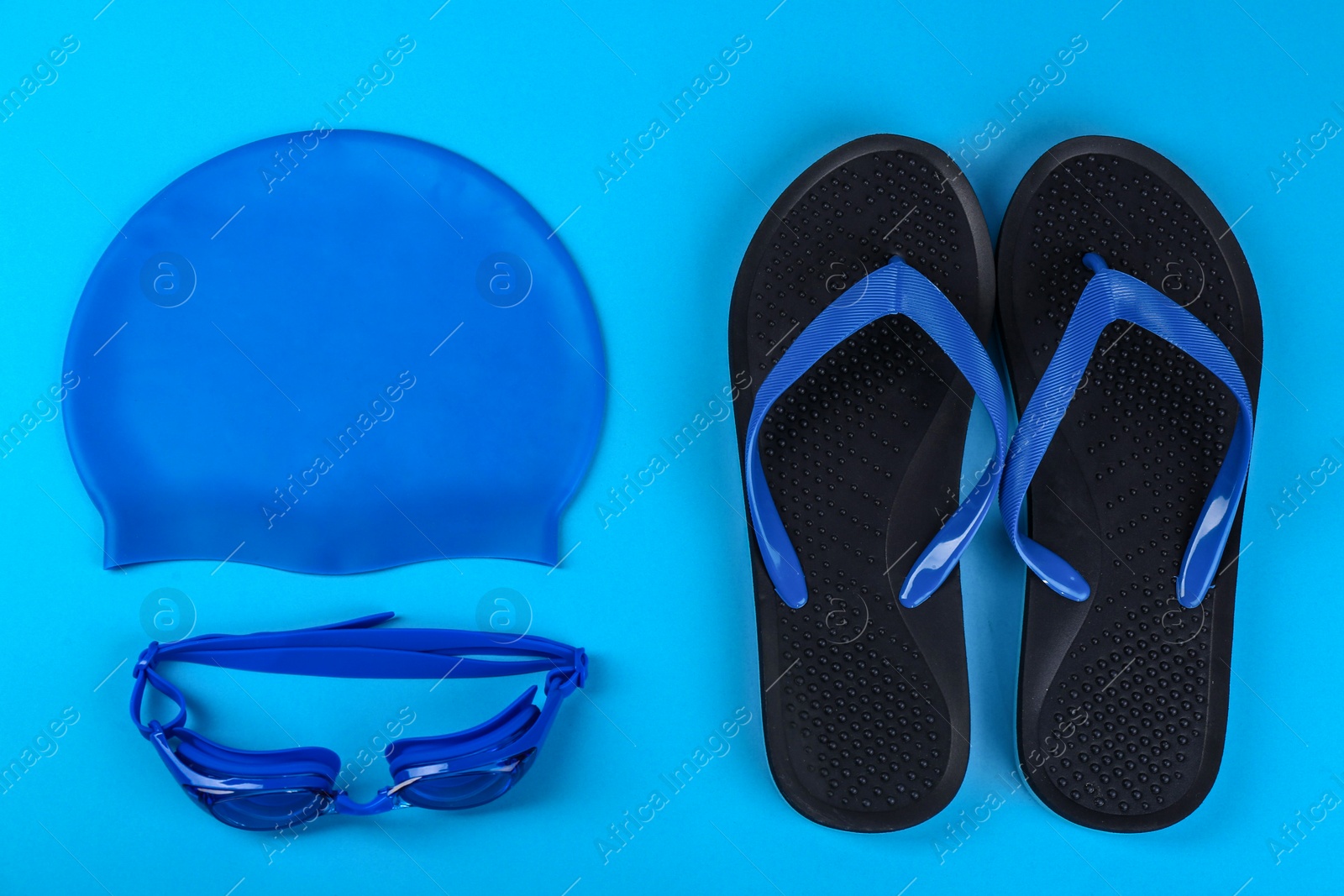 Photo of Flat lay composition with swimming accessories on light blue background